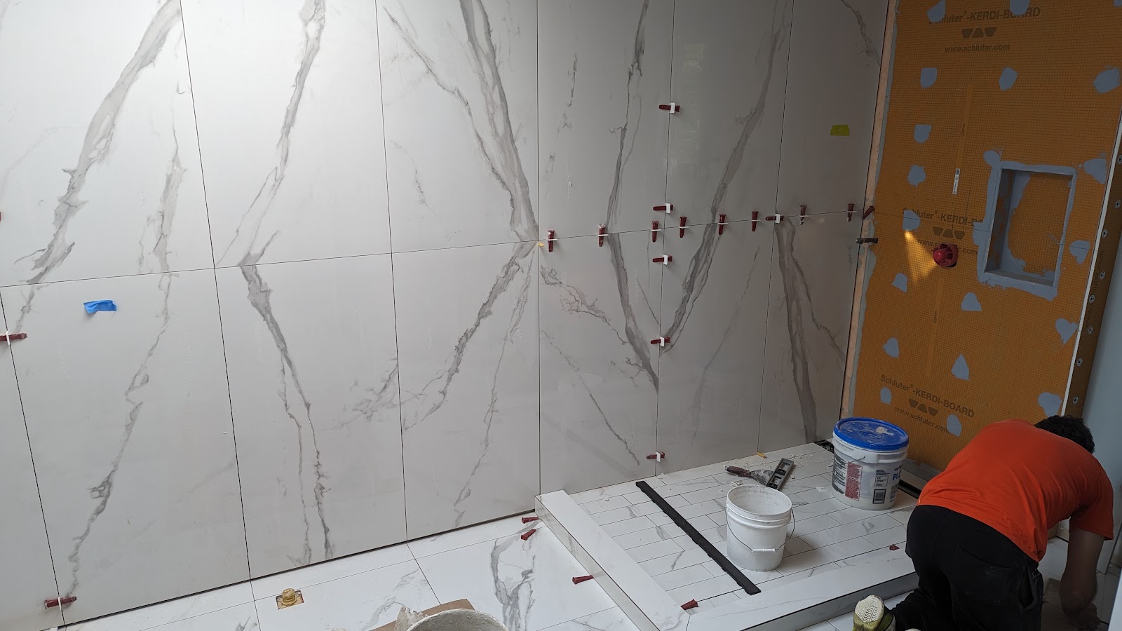 Large-format bathroom tile installation in progress