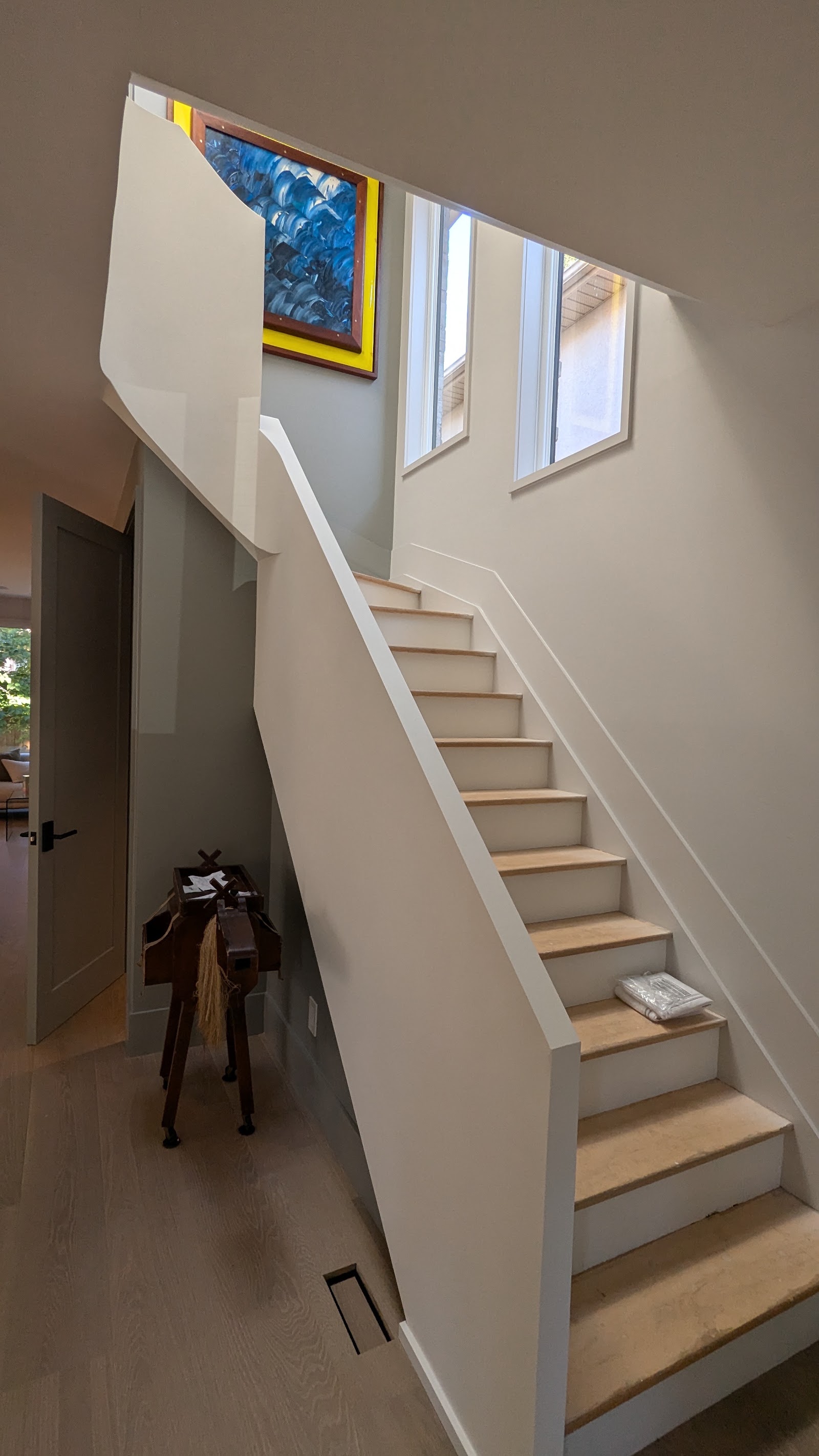 Finished staircase with clean walls, trim, and wood treads